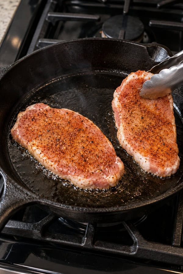 cooking meat in hot skillet