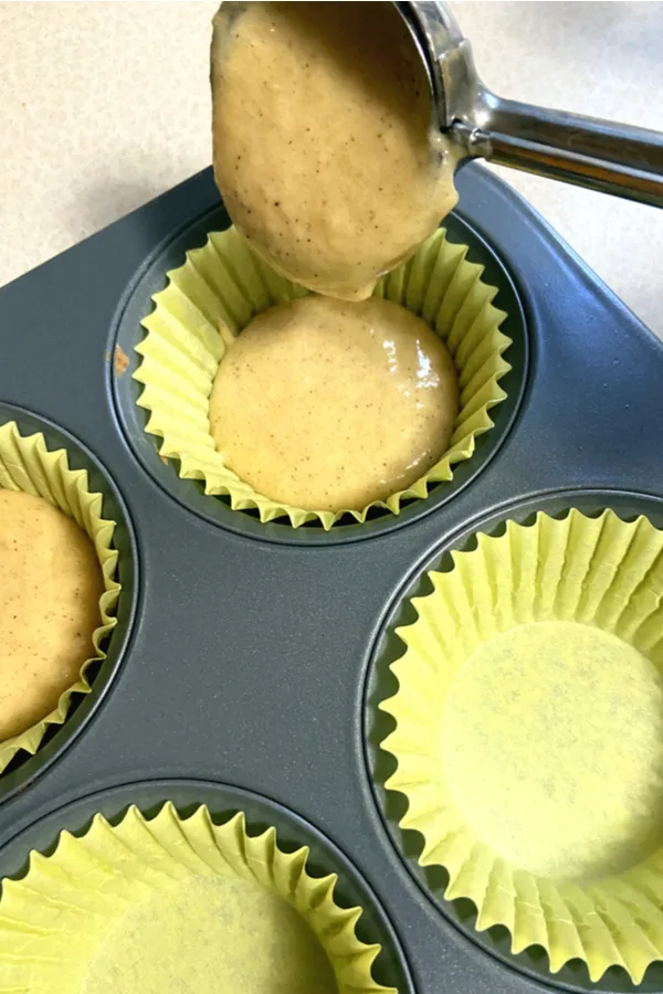 cupcake batter poured in yellow muffin cups in a muffin pan