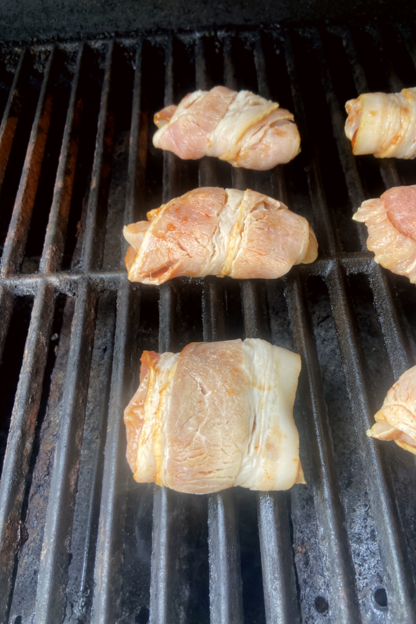 bacon wrapped chicken raw on a grill