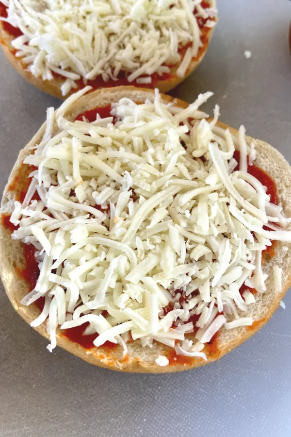 shredded mozzarella cheese on top of pizza sauce 