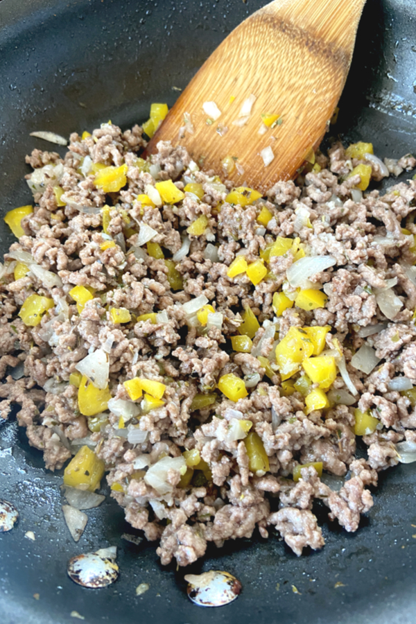 ground beef onions and yellow bell pepper in skillet 