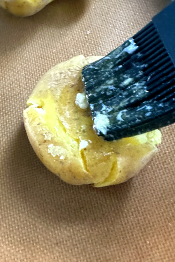pastry brush with butter on potatoes 
