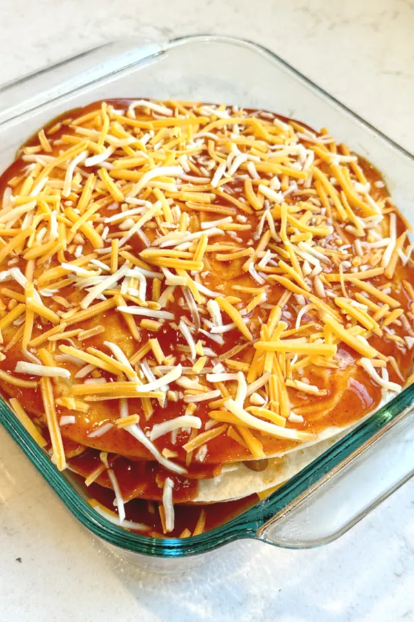 Cheese, red sauce on top of layered tortillas