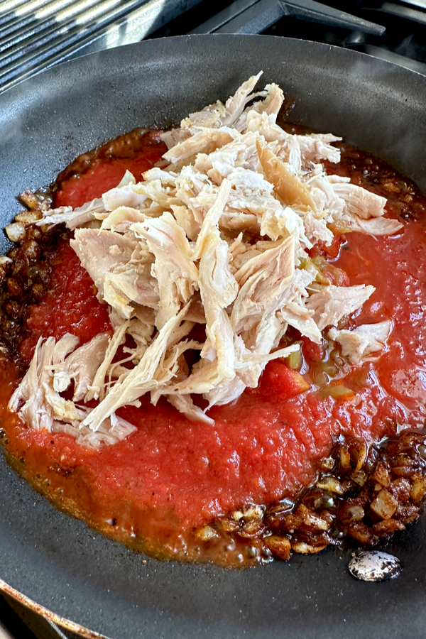 rotisserie chicken in skillet with tomatoes
