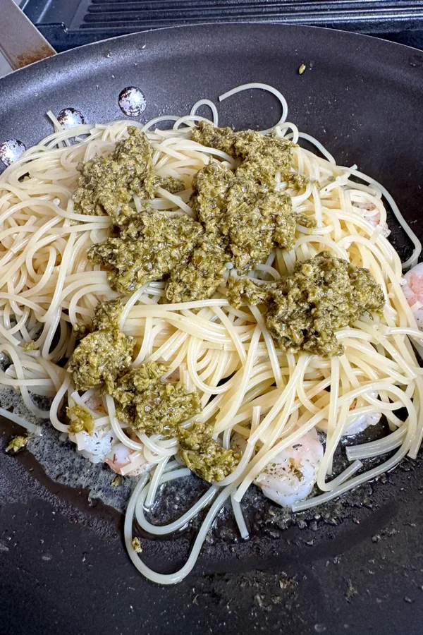pesto on pasta and shrimp in skillet