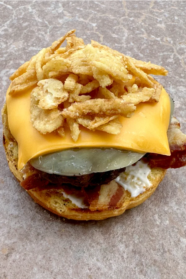 fried onions on a bacon cheeseburger 
