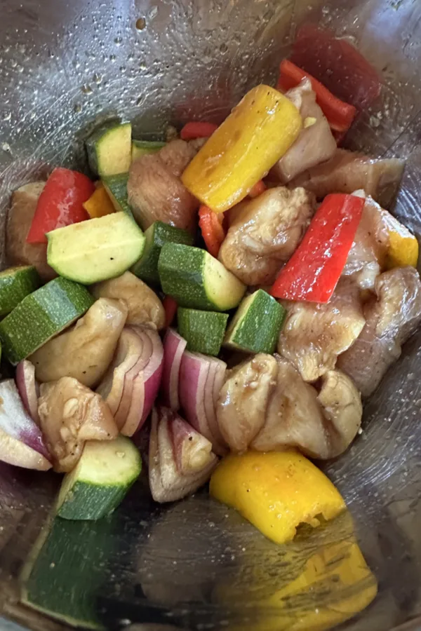 veggies and chicken breast pieces in marinade