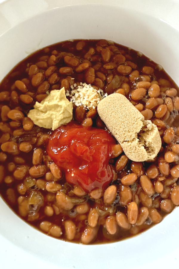 baked beans topped with ketchup, brown sugar, mustard and minced onion