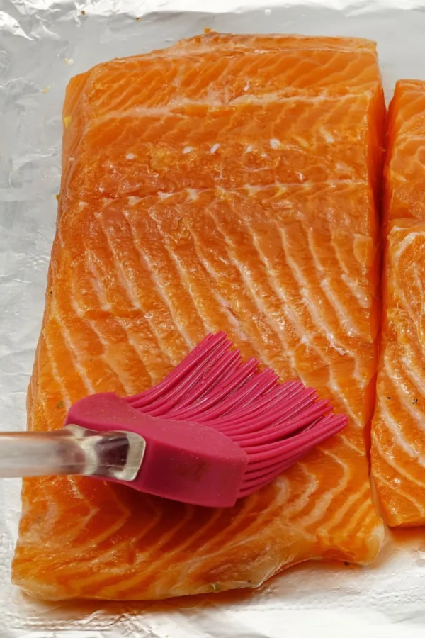 brushing raw salmon filet with oil 