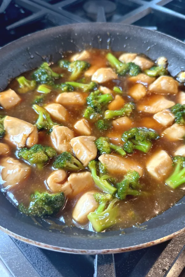 diced chicken breast and broccoli in a brown sauce in a skillet