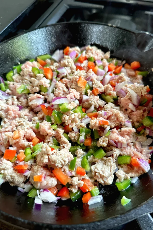 ground turkey peppers and onions in a skillet 