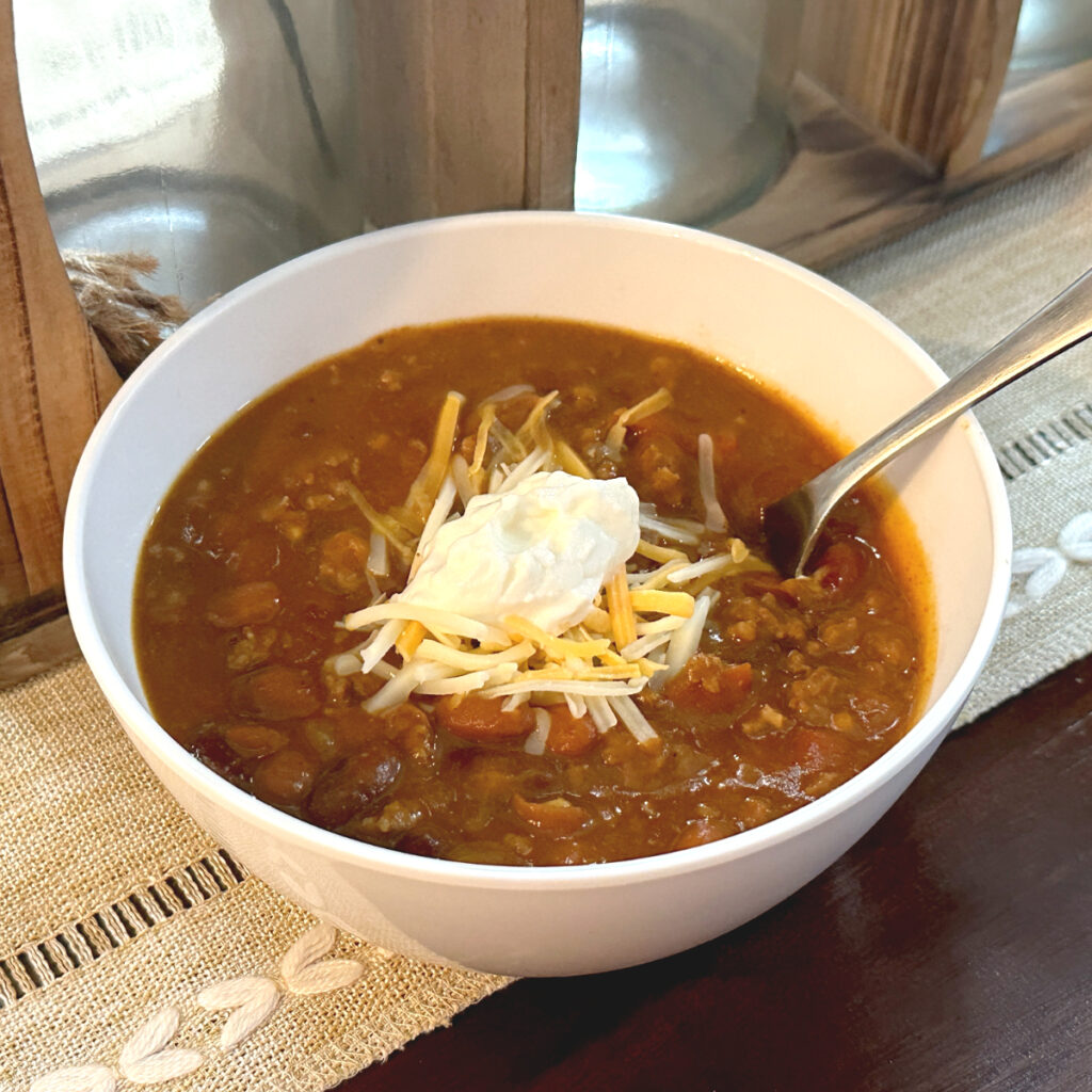 pumpkin chili with shredded cheese and sour cream on top