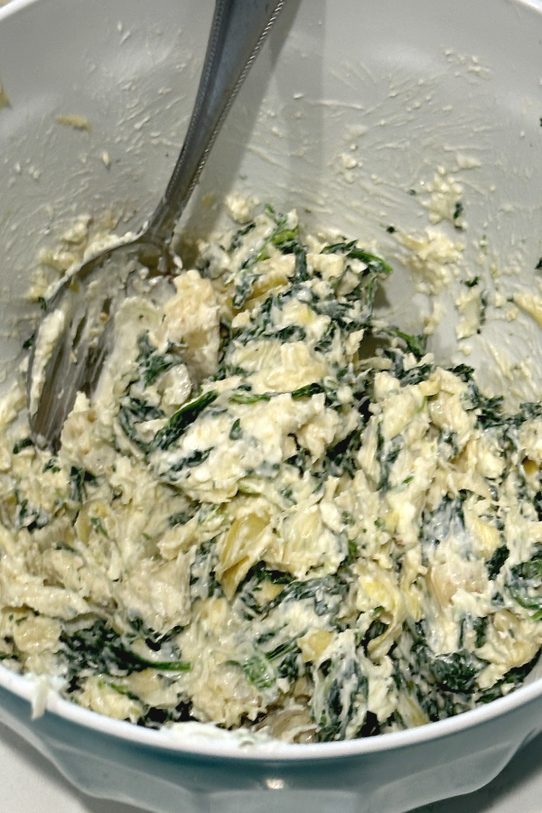 mixing spinach artichoke dip ingredients 