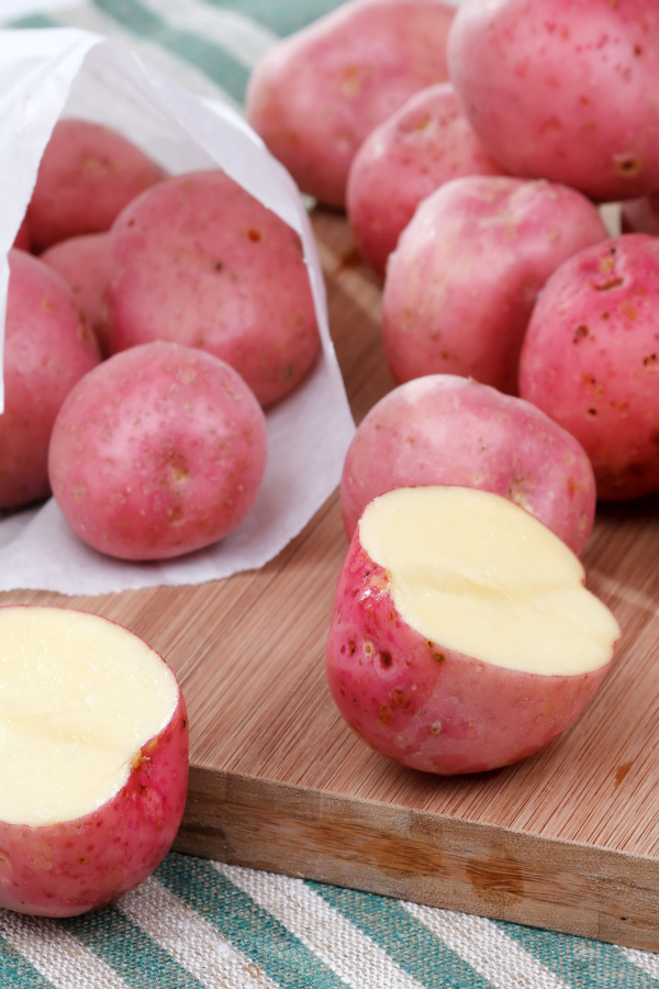 red skin potatoes on a cutting board.