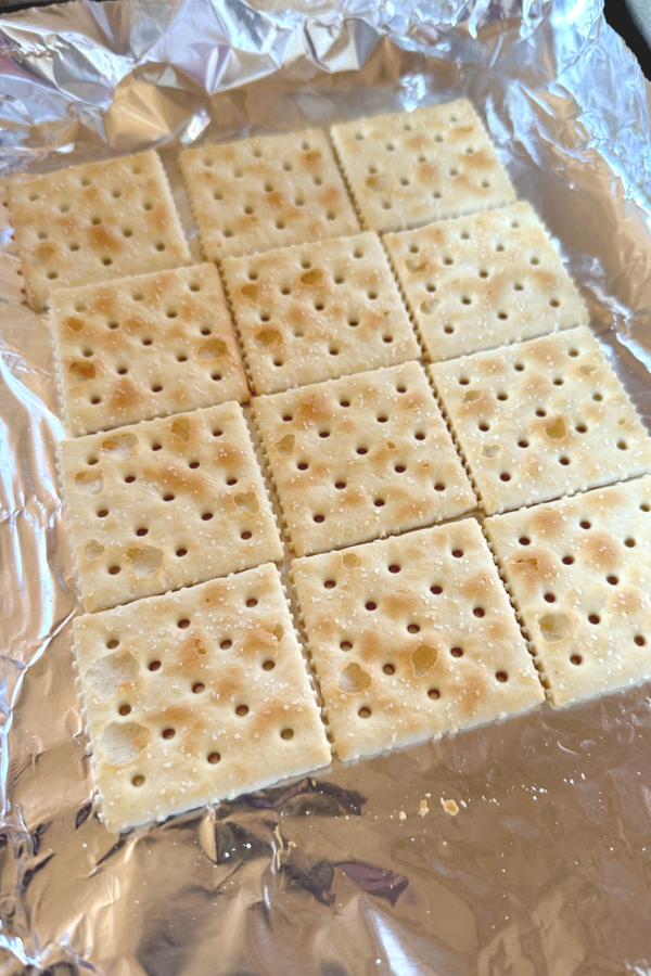 layer of saltine crackers on foil in baking dish