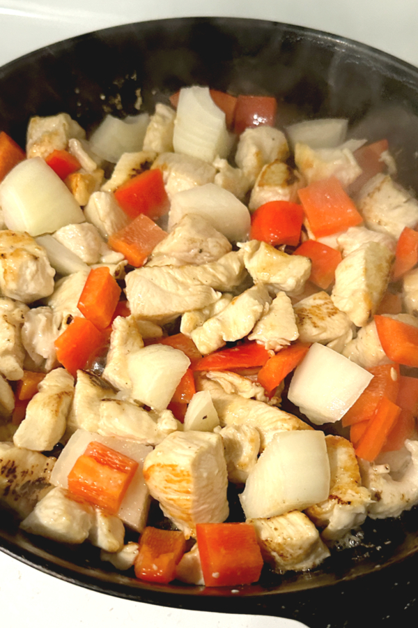 chicken peppers and onions in a skillet 