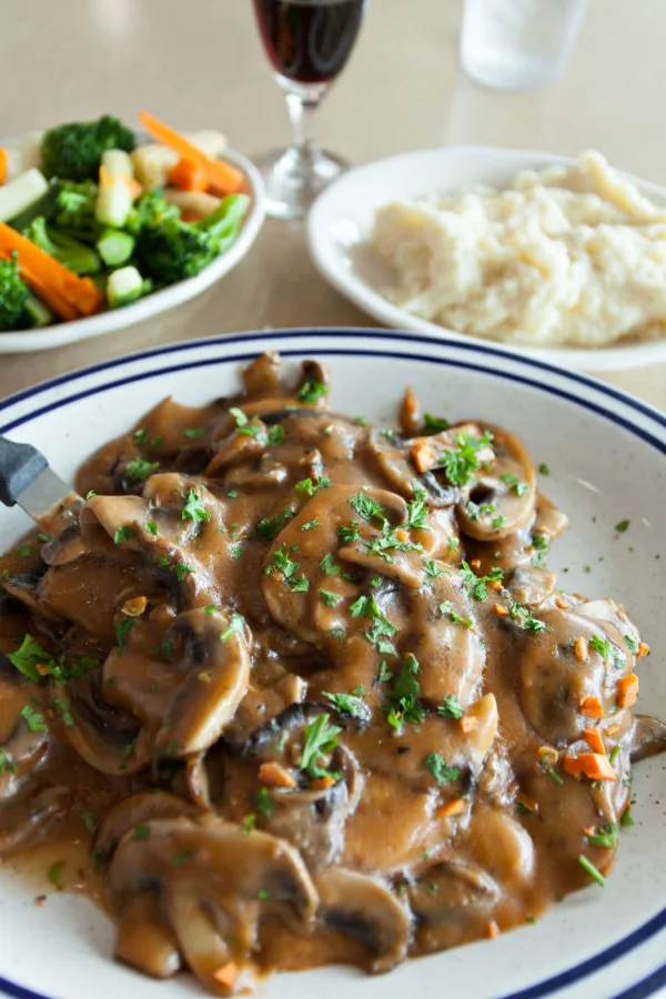 chicken marsala served with mashed potatoes and vegetables
