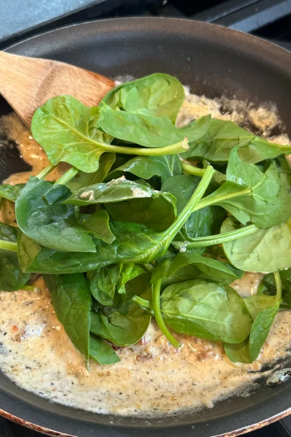 fresh spinach leaves in skillet
