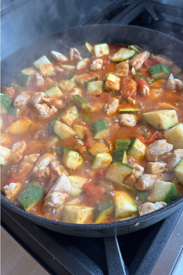 zucchini in skillet with chicken and red sauce