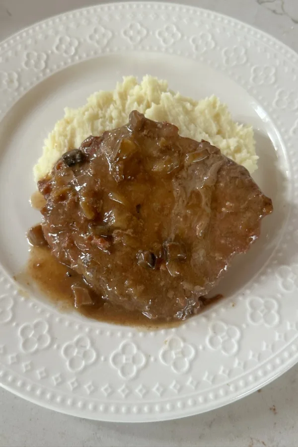 cube steak and gravy served over mashed potatoes