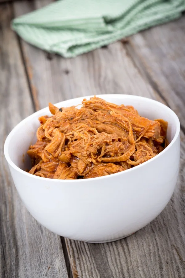 strands of meat in white bowl